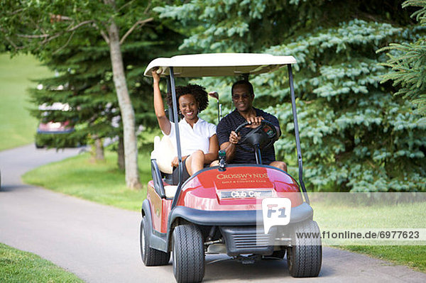 Couple Riding in Golf Cart