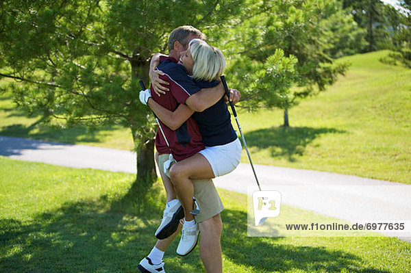 Couple Embracing on Golf Course