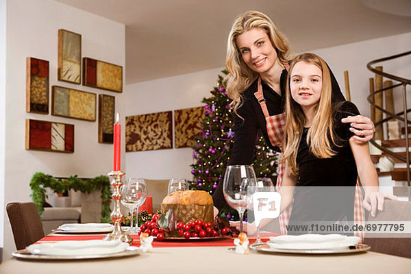 Mother and Daughter Setting Table for Christmas Dinner