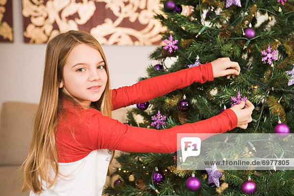 Mädchen dekorieren Weihnachtsbaum