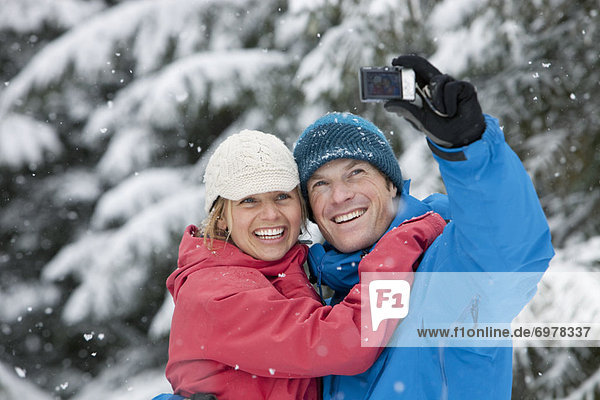 Couple Taking Self Portrait with Camera Phone Outdoors in Winter  Whistler  British Columbia  Canada