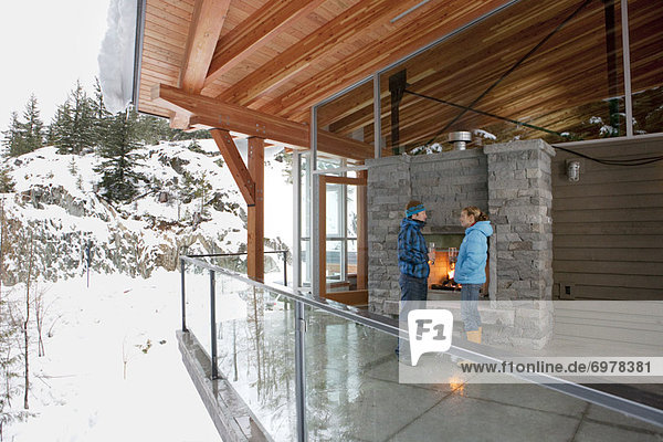 Couple standing on Balcony of Chalet in Winter  Whistler  British Columbia  Canada