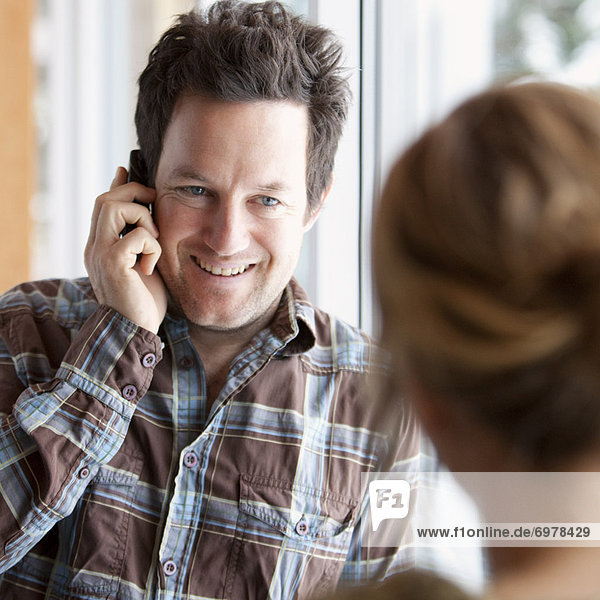 Man Looking at Woman While Talking on Cell Phone