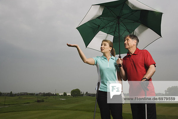 Menschlicher Vater  Regenschirm  Schirm  halten  groß  großes  großer  große  großen  Tochter  Golfsport  Golf  Kurs