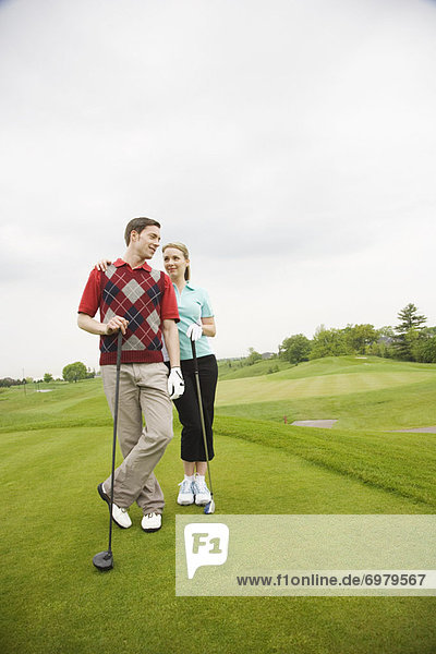 Paar stehend auf Golfplatz