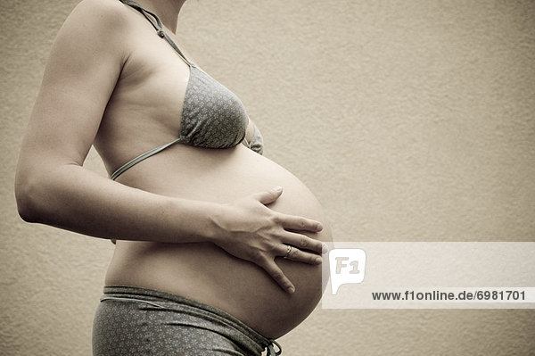 Profile of Woman  Nine Months Pregnant  Touching Her Belly