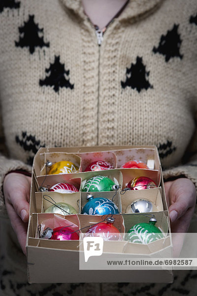 Woman Holding Box of Christmas Ornaments