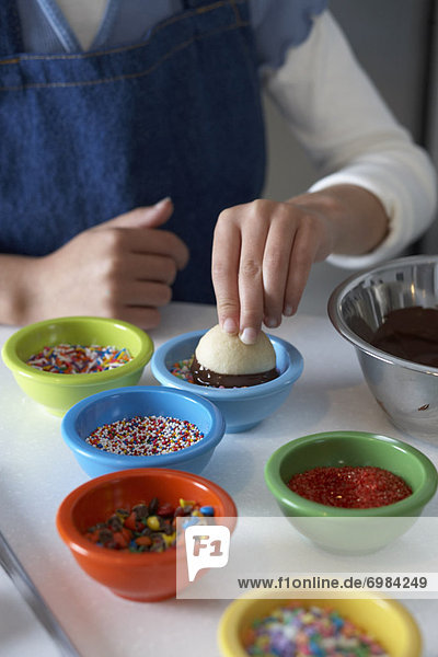 Woman Dipping Shortbread into Chocolate and Sprinkles
