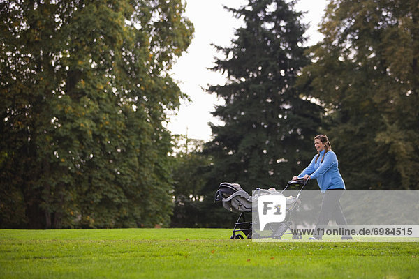 Woman Pushing Stroller in Park  Seattle  Washington  USA