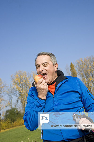 Außenaufnahme  Mann  reifer Erwachsene  reife Erwachsene  Apfel  essen  essend  isst  freie Natur