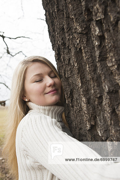 Young Woman Hugging Tree