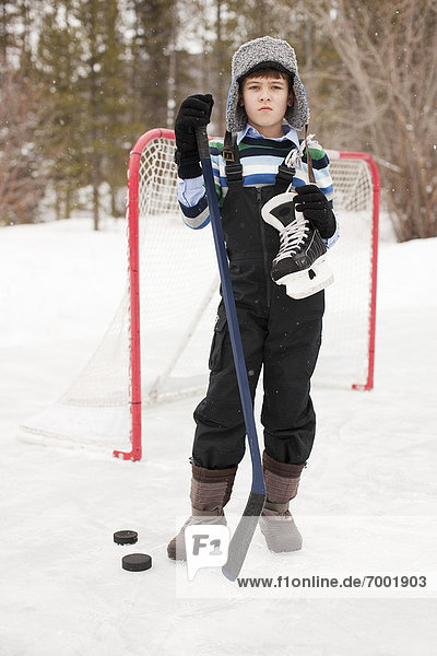Boy Holding Hockey Skates and Hockey Puck  Frisco  Summit County  Colorado  USA
