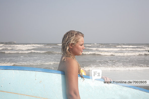 Young Woman holding Surfboard on Beach  Galveston Beach  Galveston  Texas  USA
