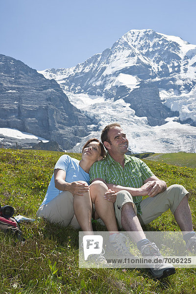 Couple Sitting on Mountain Side  Bernese Oberland  Switzerland