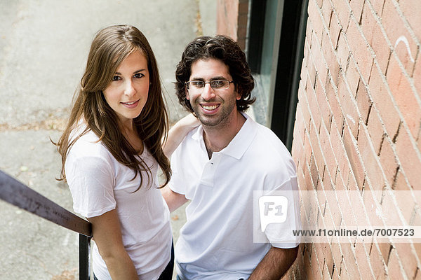 Close-up Portrait of Young Couple Standing on Fire Escape