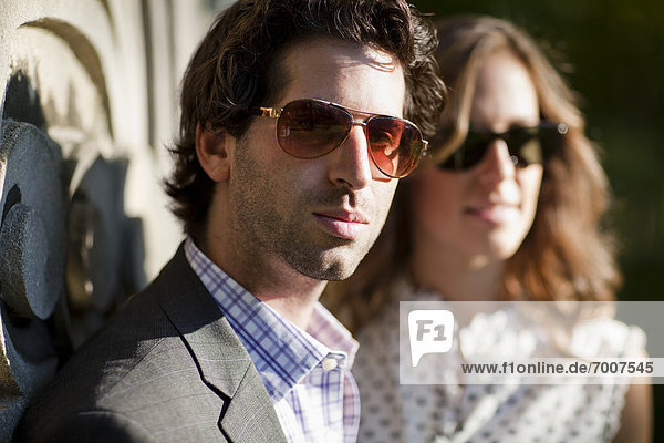 Close-up Portrait of Young Couple Standing in front of Stone Sculptures in Park  Ontario  Canada