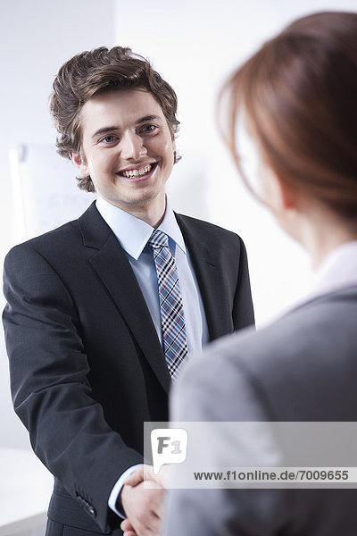 Young Businessman Shaking Hands with Businesswoman