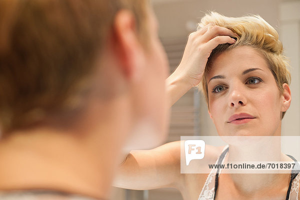 Frau untersucht sich im Spiegel