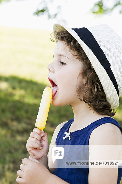 Girl eating popsicle outdoors