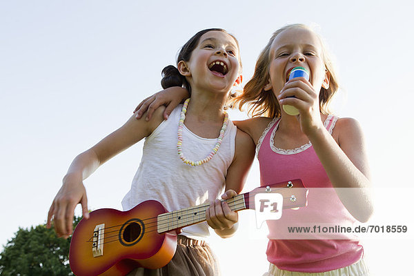 Mädchen singen gemeinsam im Freien
