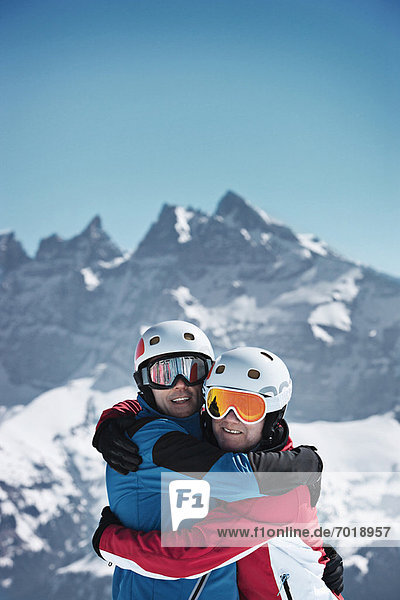 Skiers hugging on snowy mountain