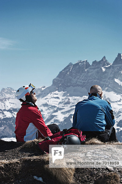 Skifahrer  die sich auf einer felsigen Bergspitze ausruhen