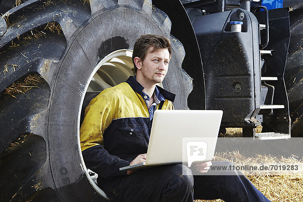 Farmer using laptop in field