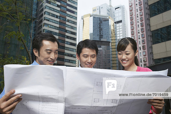 Business people reading blueprints