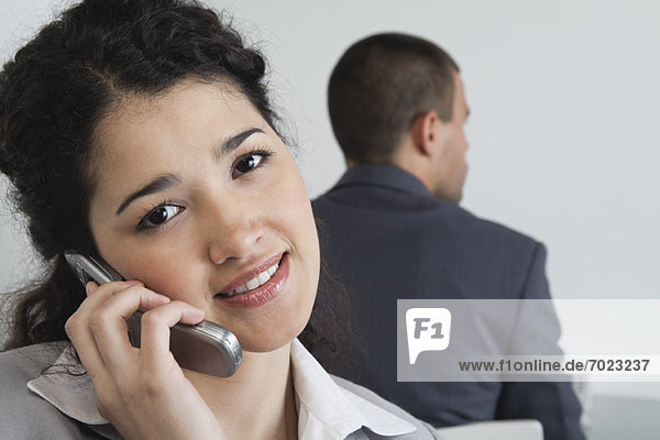 Junge Geschäftsfrau mit Handy im Büro