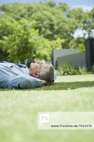 Erwachsener Geschäftsmann schläft auf Gras