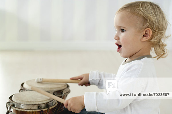 Baby Junge spielt Schlagzeug  Seitenansicht