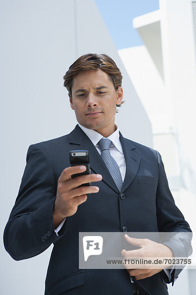 Businessman text messaging with cell phone