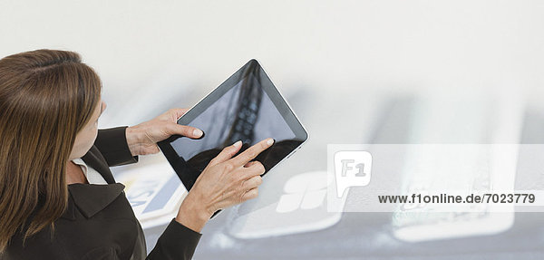 Woman using digital tablet  image of wallet containing credit cards superimposed on background