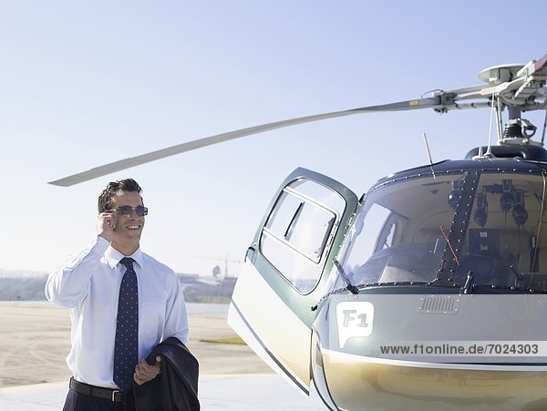 Handy nahe benutzen Geschäftsmann Hubschrauber