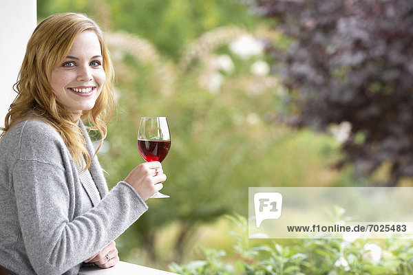 Young woman drinking red wine (portrait)