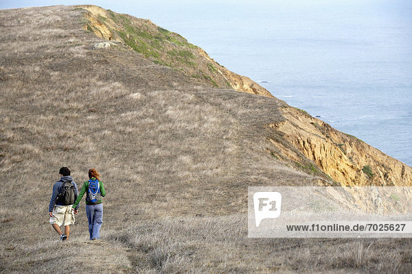 Man and woman hiking near cliff
