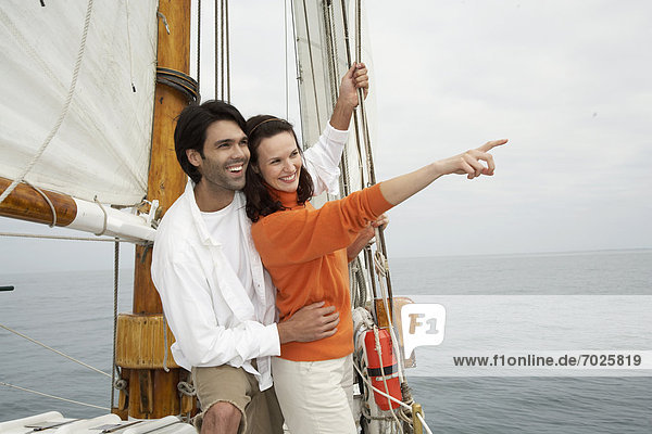 Young couple looking at view in sailboat