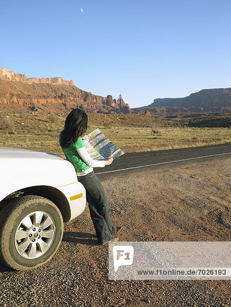Woman reading map in desert  rear view  Moab  Utah  USA