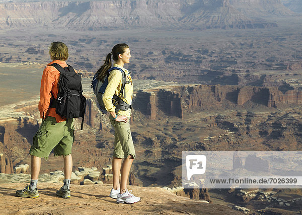 Two hikers looking at rock strata