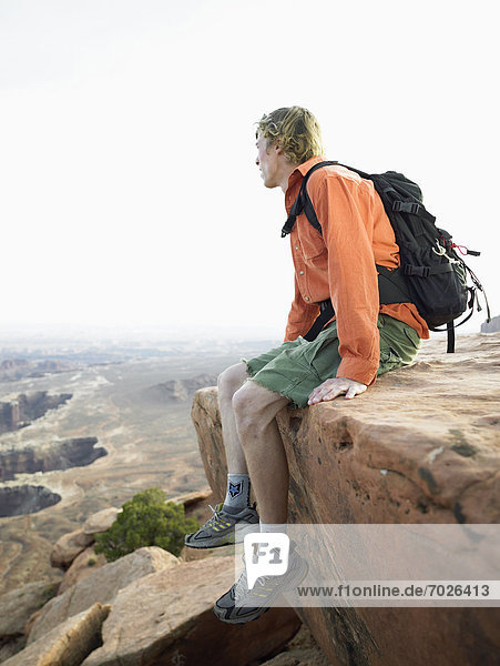 Male hiker sitting on cliff