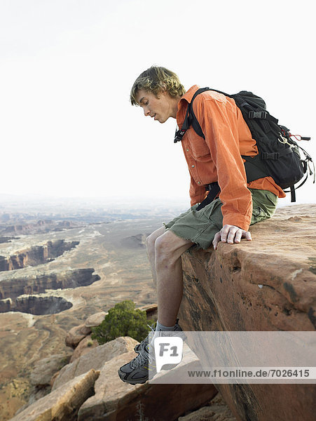 Male hiker looking down on cliff