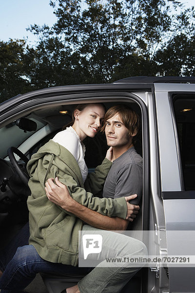 Woman sitting on man's lap in car (portrait)