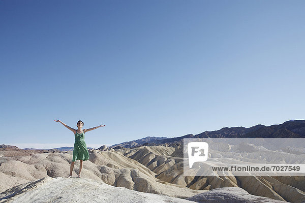 Vereinigte Staaten von Amerika USA Felsbrocken stehend Frau Arme ausbreiten Arme ausstrecken Death Valley Nationalpark strecken Kalifornien