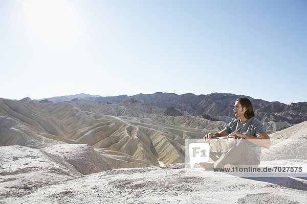 Man playing drums in desert  Death Valley  California  USA