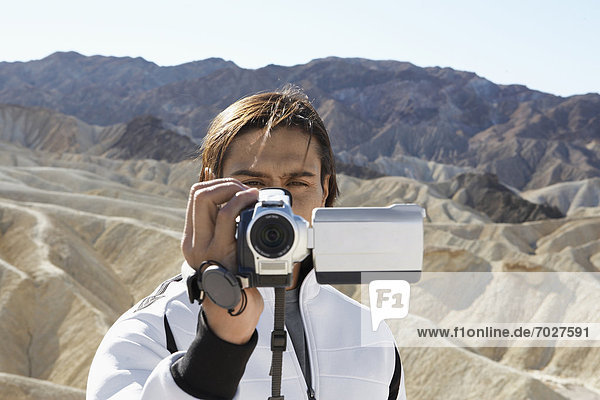Man using video camera in desert  Death Valley  California  USA