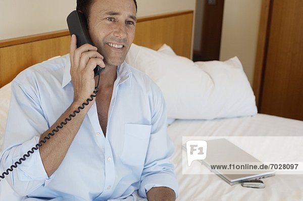 Businessman on phone in hotel room
