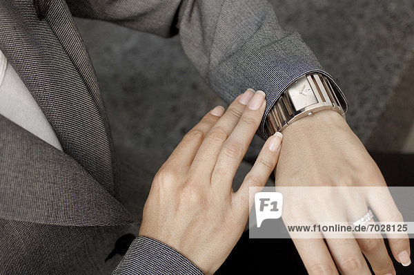 Businesswoman checking the time from wrist watch (close-up)