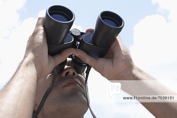 Young man looking through binoculars