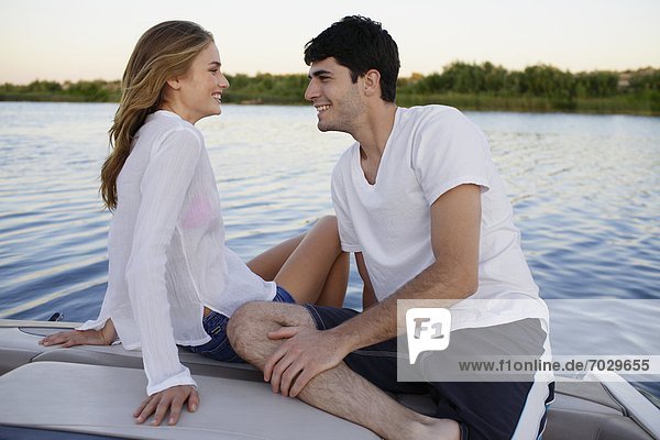 Young couple on motorboat at lake