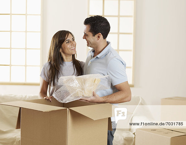 Mid-Adult Couple Unpacking Cardboard Boxes